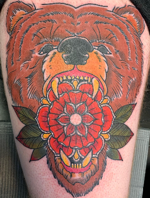 Traditional roaring bear with a red mandala rose on a thigh