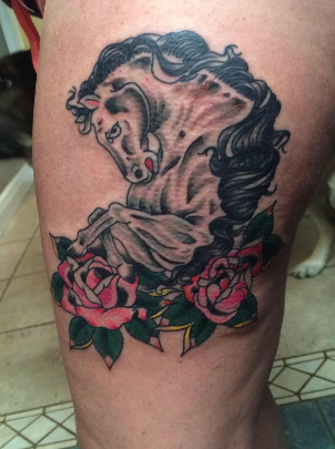 Black and grey rearing horse framed by traditional roses