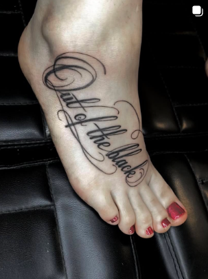 Fine-line script lettering reading Out of the blue across a foot